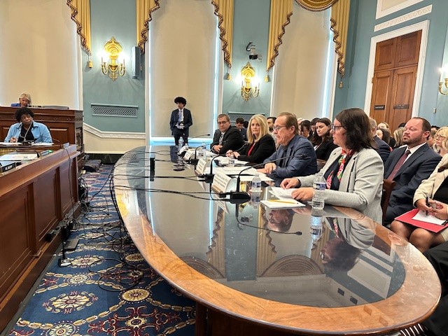 Cooper (second from right, speaking) testifies before the House Agriculture Committee.